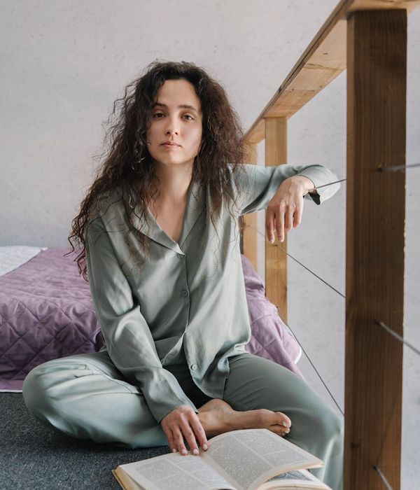 Person meditating peacefully in a natural setting with soft light.